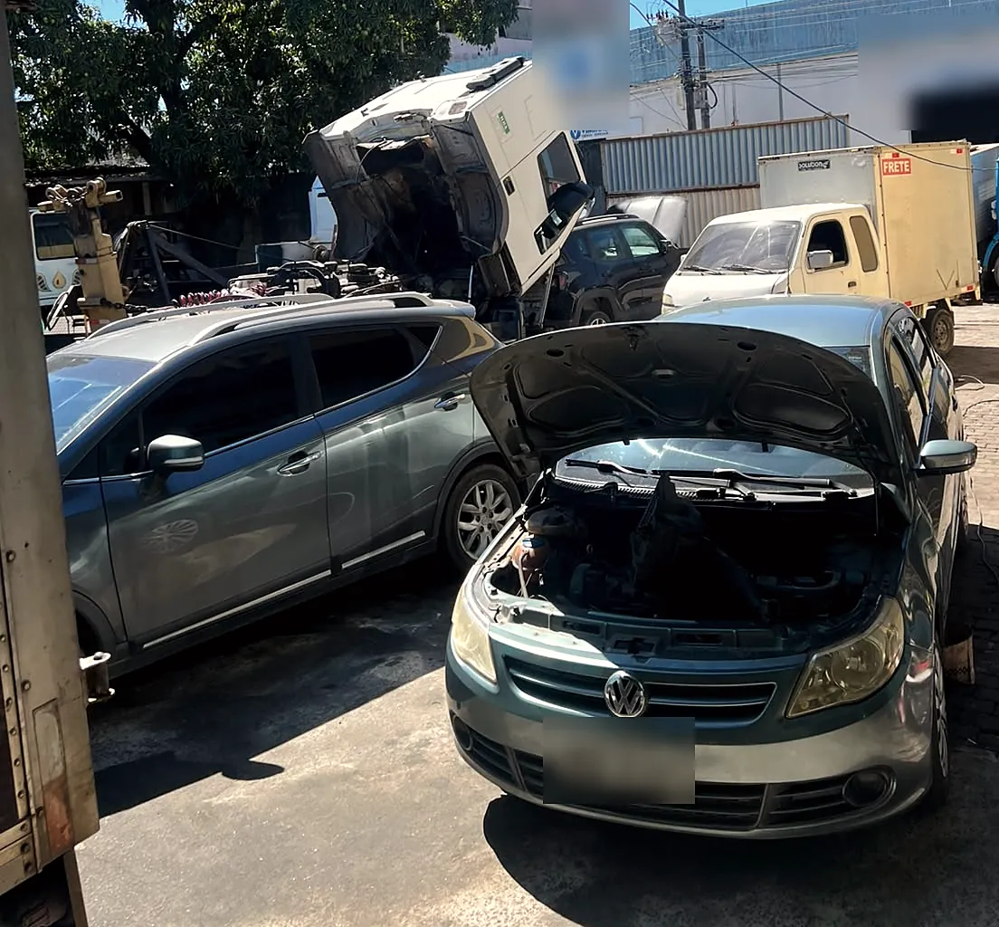 Carro com o capô aberto no pátio da oficina